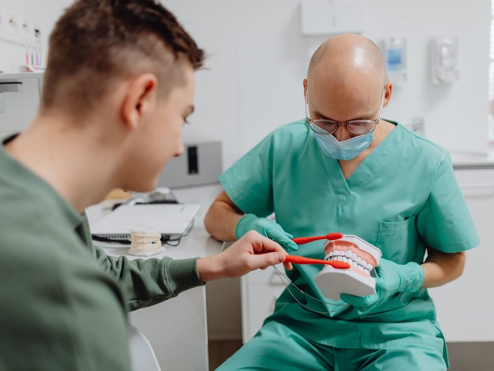 Dentist explaining brushing on a model